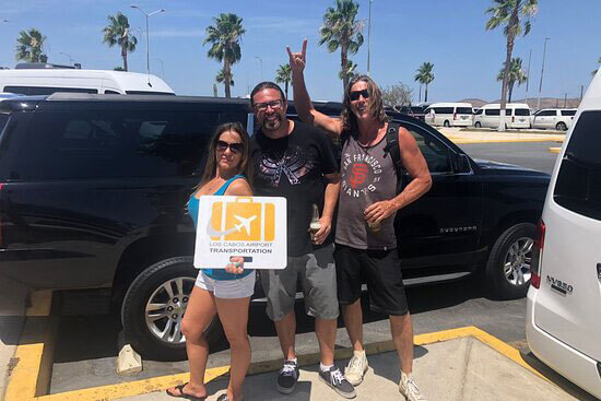 Group of three friends about to enjoy a ride in a black Suburban luxury SUV 